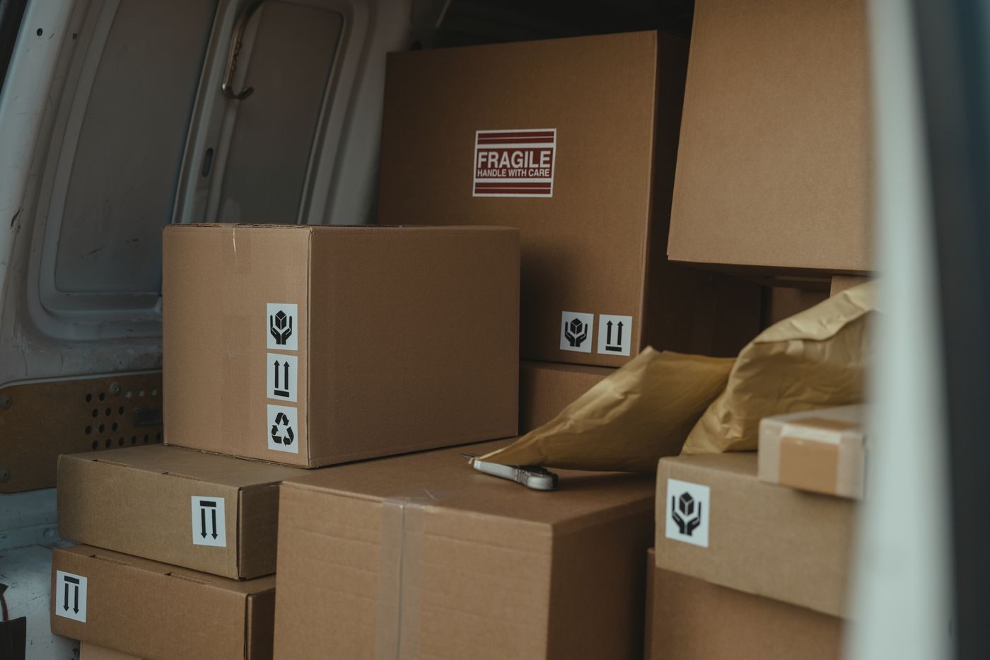 Boxes stacked and labelled fragile inside a loaded van
